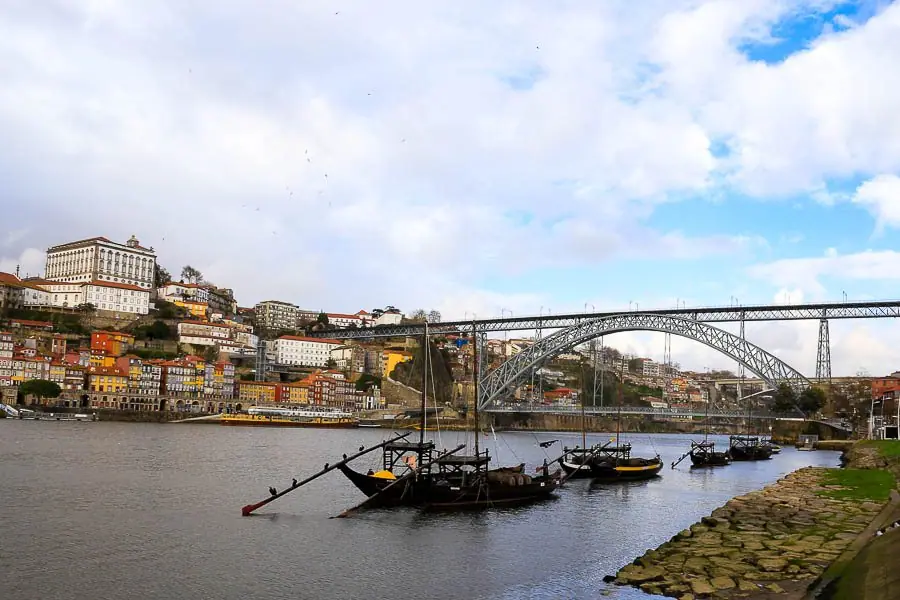 Rabelo boats moored on the Douro in front of the Ribeira, with the Dom Luís I bridge and Porto behind